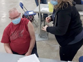 Randy Young receives his COVID-19 immunization from registered nurse Shannon McInnis at the AHS COVID-19 immunization clinic at the Suncor Community Leisure Centre curling rink at MacDonald Island Park in Fort McMurray on April 5, 2021. Photo courtesy of AHS