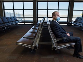 James Bogusz strikes a solitary profile sitting alone in an empty passenger lounge at the Regina International Airport, where he’s the chief executive. Bogusz says the airport can get by with fewer passengers than before the pandemic, “but I can’t make it work with 10 per cent.” (BRANDON HARDER/ Regina Leader-Post)