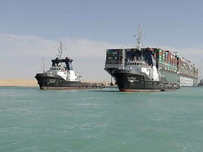 A picture released by Egypt's Suez Canal Authority on March 29, 2021, shows a tugboat pulling the Panama-flagged MV 'Ever Given' container ship after it was fully dislodged from the banks of the Suez.  The ship was refloated and the Suez Canal reopened, sparking relief almost a week after the huge container ship got stuck and blocked a major artery for global trade.