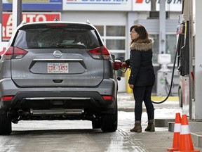 A motorist fills up with gas at the Petro-Canada station in downtown Edmonton on Tuesday December 31, 2019.  Alberta has to decide whether to stick with the federal carbon pricing backstop or implement its own plan. The former costs drivers more at the pump, but the latter would not necessarily have to.