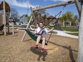 Lennon Jackson, 6, left, and her cousin Adelle LeBlanc, 15, enjoy the big swing on opening day of Lorne Avenue Park in London on Wednesday April 28, 2021. The park is on the site of the former Lorne Avenue public school in Old East London. (Derek Ruttan/The London Free Press)