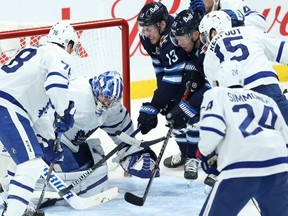 Winnipeg Jets forwards Pierre-Luc Dubois (centre) and Paul Stastny (centre right) try to jam a puck past Toronto Maple Leafs goaltender Jack Campbell during last night’s game in Winnipeg. KEVIN KING/Postmedia Network