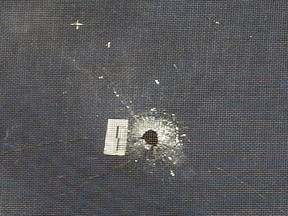 A bullet hole is visible in the second-floor window of a home on Walker Street in London after shots were fired at it. Photo taken March 2, 2021. Mike Hensen/The London Free Press Mike Hensen/The London Free Press/Postmedia Network ORG XMIT: POS2103021444340198