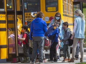 Students get on their school buses at Eagle Heights public school in London on Wednesday April 7, 2021. (Mike Hensen/Postmedia file photo)