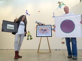 Unity Project's Sylvia Langer and museum director Brian Meehan hold pieces for their annual Up With Art Fundraiser in London, Ont. (Mike Hensen/The London Free Press)