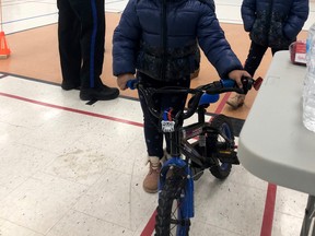 Melat, 4, stands with a bicycle she received at a recent event which provided free bikes and training on cycling and street safety in Owen Sound to newcomers. Her sister, Arsama, 6, is behind her. (Supplied photo)