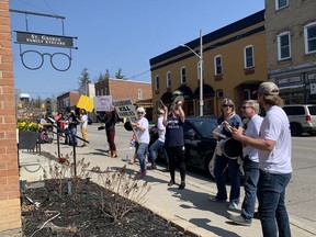 Demonstrators demanding an end to pandemic lockdowns gather Thurday at St. George Family Eyecare Centre, the business office of Brantford-Brant MPP Will Bouma, after a march along St. George's Main Street.