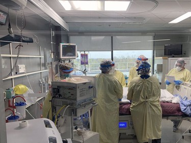 Registered nurses gather around the bed of a COVID-19 patient to administer a lifesaving technique that turns the patient, who is attached to a ventilator and other medical equipment, from his back to his front. Vincent Ball