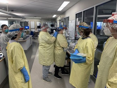 Registered nurses in the critical care ward of Brantford General Hospital help each other with their personal protective equipment before entering a COVID-19 patient's room. Vincent Ball