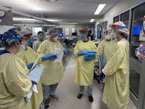 Registered nurses in the critical care ward of Brantford General Hospital huddle before entering a COVID-19 patient's room.