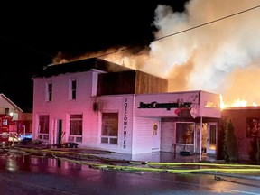 Firefighters battle a blaze that left nine people homeless and destroyed two businesses in Spencerville early Friday morning. (SUBMITTED PHOTO)