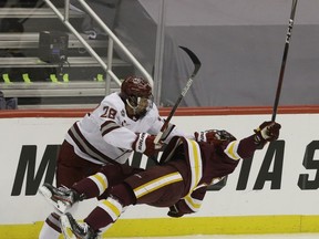 UMass Minutemen forward and former Brockville Brave Eric Faith (left) checks Minnesota Duluth Bulldogs defenceman Darian Gotz during their semi-final game at the 2021 Frozen Four NCAA hockey tournament in Pittsbugh last month. Charles LeClaire-USA TODAY Sports