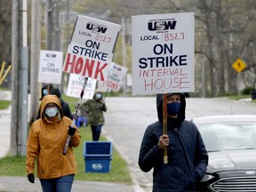 Trudy Arthur, left, and Heidi Hatch join fellow Interval House workers in a small picket on Park Street on April 27. The workers have reached a deal with management. (FILE PHOTO)