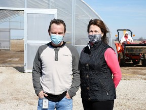 Brendon Dittmer, Mariwell master grower, left, and Theresa Robert, vice president of finance, are shown outside the hoop house at the eight-acre outdoor cannabis farm near Wheatley March 30, 2021. The company is heading into its second growing season.