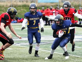 PETER RUICCI
About to cut inside of a block by Rob Wright, Sault Sabercats runner Nick Pagnotta looks for yardage in a 2019 OFC varsity game against Brantford at Superior Heights.