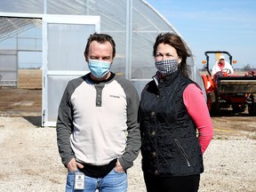 Brendon Dittmer, Mariwell master grower, left, and Theresa Robert, vice president of finance, are shown outside the hoop house at the eight-acre outdoor cannabis farm near Wheatley. The company is heading into its second growing season.