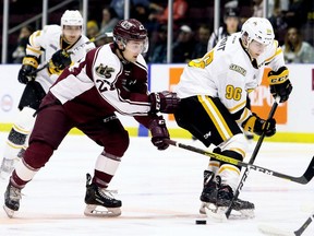 Sarnia Sting's Ty Voit (96) tries to protect the puck from Peterborough Petes' Brady Hinz (27) in an Ontario Hockey League game at Progressive Auto Sales Arena on Oct. 11, 2019.