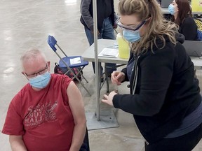 Randy Young receives his COVID-19 immunization from registered nurse Shannon McInnis at the AHS COVID-19 immunization clinic at the Suncor Community Leisure Centre curling rink at MacDonald Island Park in Fort McMurray on April 5, 2021. Photo courtesy of Alberta Health Services