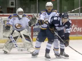 Grande Prairie Storm captain Dan McIntyre battles with Oil Barons defenceman Brendan Wang during the second period of Alberta Junior Hockey League action in Grande Prairie on Saturday night. The Storm picked up a 3-1 win, handing the Oil Barons their first regulation loss this season,