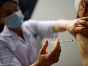 A health-care worker administers a dose the Pfizer vaccine.