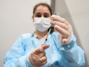 A medical worker fills a syringe with a dose of COVID-19 vaccine.
