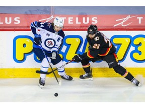Winnipeg Jets defenseman Josh Morrissey (44) and Calgary Flames center Dillon Dube (29) battle for the puck during the third period at Scotiabank Saddledome on Mar 26, 2021. Photo by: Sergei Belski-USA TODAY Sports