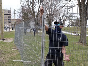 Workers erect a fence around Breakwater Park after the city announced on Friday the park's closure to prevent large gatherings.