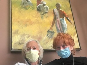 Longtime friends Inger Sparring-Barraclough, 87, and Joan Holben, 84, relax in front of a Holben original called Wheat Harvest.