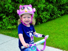 Michaela rides her bike with the help of a special device.