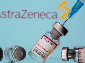 FILE PHOTO: Vials labelled "Astra Zeneca COVID-19 Coronavirus Vaccine" and a syringe are seen in front of a displayed AstraZeneca logo, in this illustration photo taken March 14, 2021.