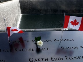 Canadian flags are seen left in the name of victim Kenneth William Basnicki at the edge of the North pool during ceremonies on the 19th anniversary of the Sept. 11, 2001, attacks on the World Trade Center at the 9/11 Memorial and Museum in New York City on Sept. 11, 2020.