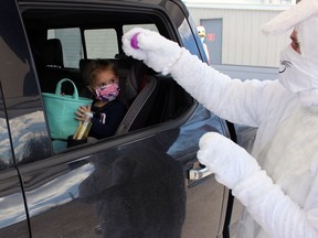 The Easter Bunny hands Lily Phillips, 3, an egg during an event hosted by the Petrolia Lions Club on Friday April 2, 2021, in Petrolia, Ont. Terry Bridge/Sarnia Observer/Postmedia Network