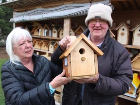 Linda and Clinton Hunter hold one of the birdhouses he made at his workshop in the backyard of their home in Plympton-Wyoming. He began making and selling birdhouses a decade ago as a way to stay busy in retirement.