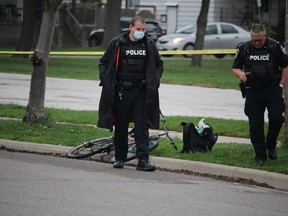 Sarnia police officers walk away Monday from a bicycle and backpack next to Brock Street, near the Sarnia Arena. A man was taken early Monday morning to hospital with a head injury, police said.