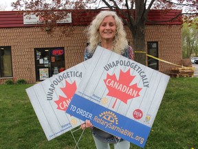 Jean Cowper, with the Rotary Club of Sarnia Bluewaterland, holds lawn signs the service club is selling as a fundraiser which also benefits the city's Canada Day committee.