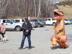 Bryan Cooper, morning show co-host at Pure Country 91.7, takes his dinosaur for a walk/dance at Bell Park in Sudbury, Ont. on Monday April 5, 2021. Actually, Cooper and dino, alias morning show co-host Josh Corbett, shot a video in the park to fulfill a promise Corbett made as part of a fundraiser for the Ontario SPCA Sudbury & District Animal Centre. The Walkin' for a Washer; Dancin' for a Dryer fundraiser raised more than $7,000 to buy a new washer and dryer for the centre. Corbett said he would wear the costume and walk and dance through the park if they raised at least $2,000.