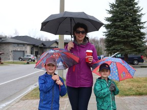 Sarah Mallory and her boys, Jack, 6, left, and Sam, 4, go for a walk in the rain in Sudbury, Ont. on Thursday April 15, 2021. John Lappa/Sudbury Star/Postmedia Network