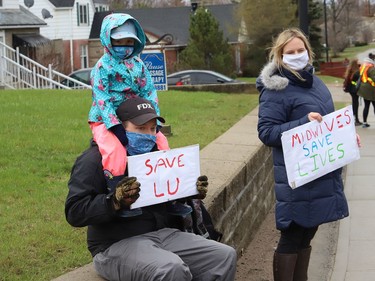 Jon and Candace Beninger, and their daughter, Anna, 4, take part in a rally to fight Laurentian University program closures in Sudbury, Ont. on Friday April 16, 2021. John Lappa/Sudbury Star/Postmedia Network