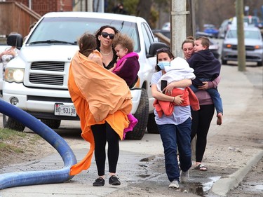 Children are moved to a safer location after a house caught fire on Lorne Street on Monday.
