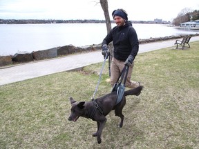 James Gallagher uses a sling to support his dog, Kai, while they go for a walk near Bell Park in Sudbury, Ont. on Tuesday April 20, 2021.