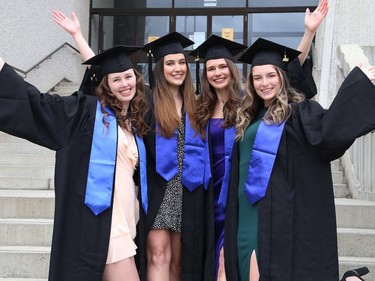 Off-campus roommates Brittany MacLeod Mayes, left, Lea Belanger, Camelie Belzile and Kaitlin Sanford purchased gowns and graduation caps online so they could take graduation pictures of themselves outside at Laurentian University on Thursday.