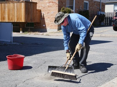 Michael Slawny, of the Polish Combatants Association, does some spring cleaning around the association's property in Sudbury on Friday.