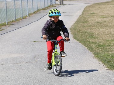 Jaden Rushton, 6, rides his bike with his grandmother at the Terry Fox Sports Complex on Friday.