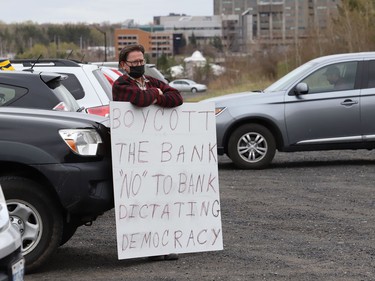 Francis Thorpe holds a sign prior to participating in a car rally to fight Laurentian University program closures in Sudbury, Ont. on Friday April 30, 2021. John Lappa/Sudbury Star/Postmedia Network