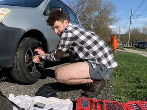 Jacob Maxwell changing from winter tires to summer ones in the driveway of the student house where he rents a room. Erica Robertson
