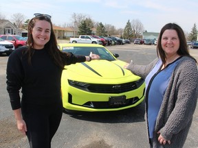Jenna Steadman, left, county coordinator with Sarnia-Lambton Rebound, and Kristin MacFarlane, general manager of MacFarlane Chevrolet Buick GMC in Petrolia, stand with the 2021 Camaro being raffled off as a fundraiser for Rebound. Paul Morden/Postmedia Network