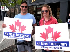 Kem and Kerry Brown of London picked up their No More Lockdowns signs Saturday in Tillsonburg. (Chris Abbott/Norfolk & Tillsonburg News)