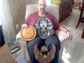 Gary Girard proudly displays some of his handiwork: a cribbage board, an Egyptian pharaoh and a Harley-Davidson sign. .TP.jpg