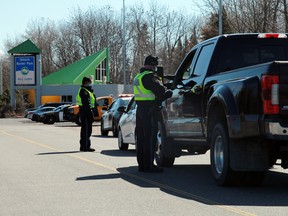 Kenora OPP officers question motorists entering Ontario at the rest stop at the provincial border with Manitoba on Monday, April 19. The Ontario government announced the reopening of its land and water borders on Monday.