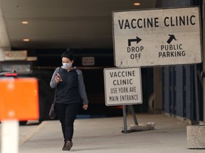 A woman wearing a mask walks by the COVID-19 vaccination supersite at the RBC Convention Centre in Winnipeg on Monday, April 5, 2021.